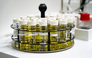 In einem Karussell auf einem Laborgerät befinden sich Probenfläschchen mit einer gelben Flüssigkeit.